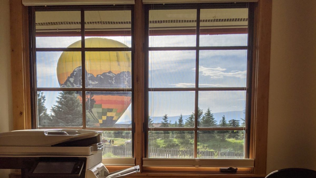 A hot air balloon lands near the Teton Village District Offices in Teton Village, WY.