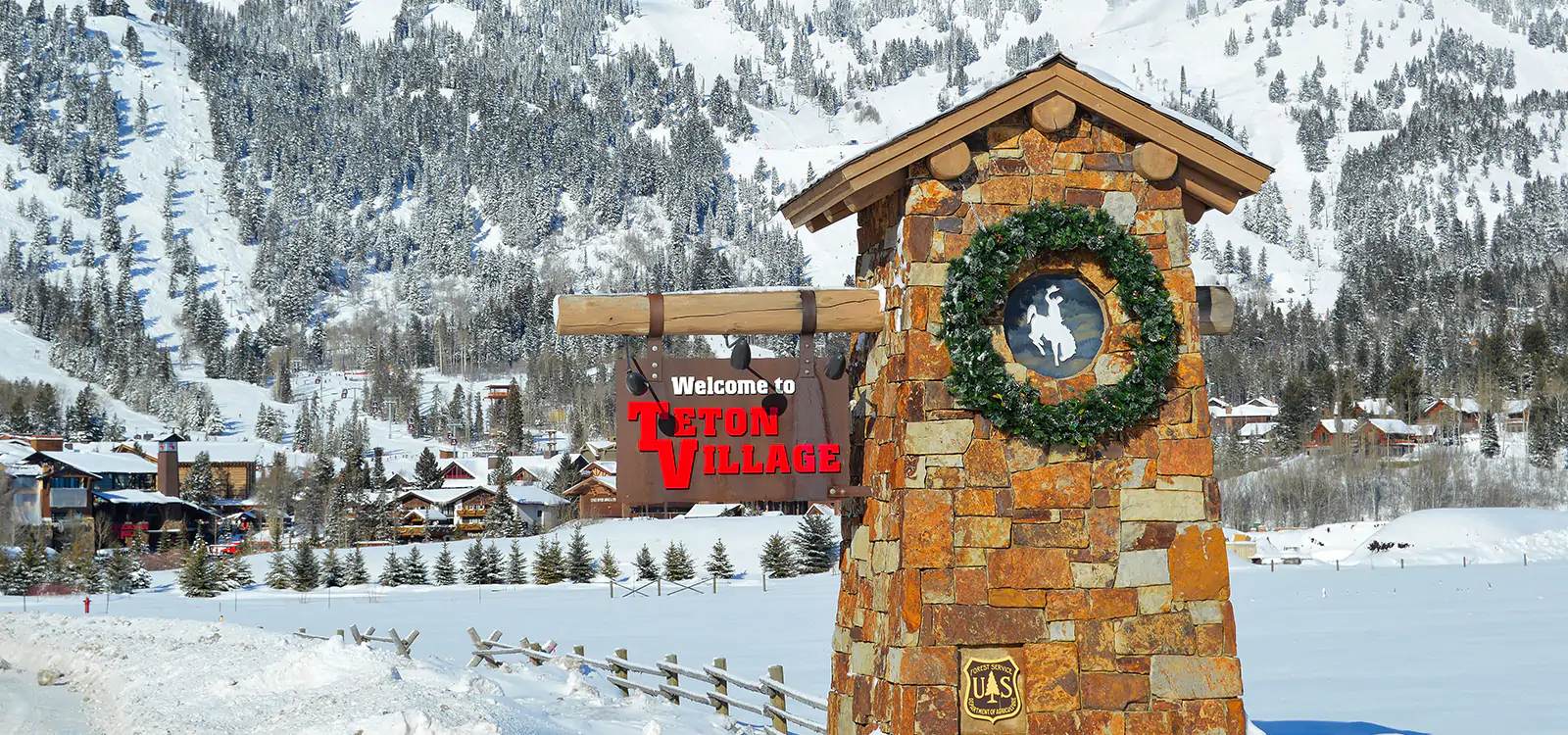 The Teton Village welcome sign, adorned with a wreath, near the entrance of Teton Village, WY.